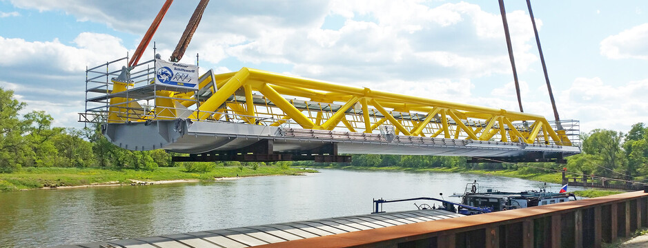 Flood barrier is loaded onto a ship for transport.
